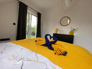 uma cama com um cobertor amarelo e uma fita azul em Apartament Masuria SPA Renata Rosłoń em Świętajno