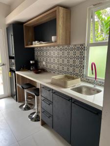 una pequeña cocina con fregadero y ventana en Subtropica Premium Suites - Mindo, en Mindo