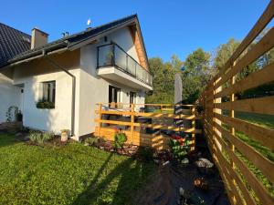 a fence in front of a house with a balcony at Apartament Masuria SPA Renata Rosłoń in Świętajno