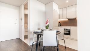 a kitchen and dining room with white cabinets and a table and chairs at Nice Circunvalação Studio I By Unique Hosts in Senhora da Hora +13 photos