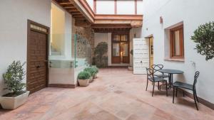 a courtyard with a table and chairs and a door at Siete LLaves by Toledo AP in Toledo