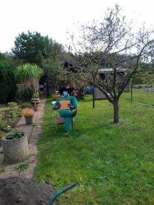 Una statua di una donna seduta su una sedia in un giardino di Remo Garten a Neubrandenburg