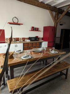 een eetkamer met een tafel en een keuken bij Au Cocon de Sologne in Soings-en-Sologne