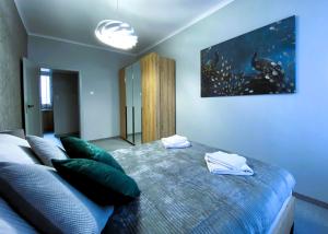 1 dormitorio con 1 cama grande con almohadas verdes en Nero Apart Częstochowa en Częstochowa