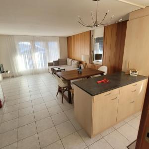 eine Küche und ein Wohnzimmer mit einem Tisch und einem Sofa in der Unterkunft Residence Edelweiss in Bellwald