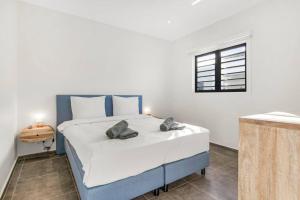 a bedroom with a large bed with two pillows on it at Villa Mambo Royale in Willemstad +10 photos