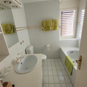 uma casa de banho com um lavatório, um WC e uma banheira em Residence Edelweiss em Bellwald