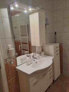 La salle de bains est pourvue d'un lavabo et d'un miroir. dans l'établissement Lena apartment - Lena two bedroom apartment, à Vecsés