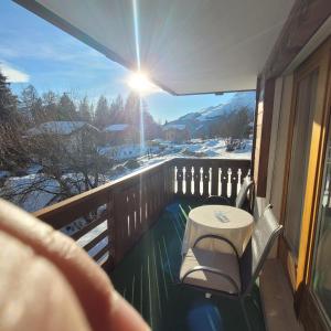 eine Veranda mit einem Tisch und Stühlen auf dem Balkon in der Unterkunft Residence Edelweiss in Bellwald