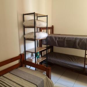 Cette chambre comprend trois lits superposés et un lit. dans l'établissement APARTAMENTO CONDOMÍNIO SUN WAY, à Ubatuba