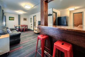 un soggiorno con bancone, divano e sgabelli rossi di A-Lodge Boulder a Boulder