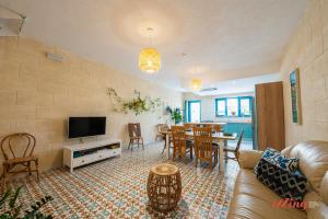 sala de estar con sofá y comedor en A remarkable Eco Home in Gozo, en Nadur