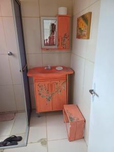 a small bathroom with a wooden sink and a mirror at Casa do Mato I in São Lourenço do Sul