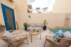 un patio con 2 sillas y una mesa en A remarkable Eco Home in Gozo, en Nadur