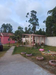 a playground in a yard with a pink house at Casa do Mato I in São Lourenço do Sul