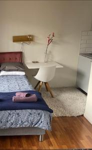 a bedroom with a bed and a desk with a vase of flowers at Studio 3 in Landskrona