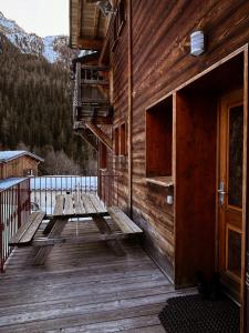 a wooden deck with a bench on the side of a building at Chalet La Savoyarde in Peisey-Nancroix