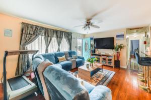 a living room with a blue couch and a tv at Colonial Heights Home with Large Yard and BBQ Grill! in Colonial Heights