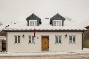 uma casa branca com uma porta castanha em Spīdalas nams em Cēsis