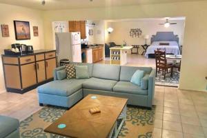 sala de estar con sofá azul y cocina en Creature Comforts Sleeps 24 4 hot tubs, en Ahwahnee