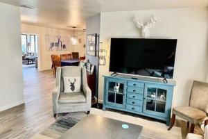 sala de estar con TV y armario azul en Creature Comforts Sleeps 24 4 hot tubs, en Ahwahnee