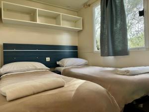 dwa łóżka siedzące obok siebie w pokoju w obiekcie Camper Village w mieście Santo Stefano al Mare
