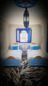 舍夫沙萬的住宿－Dar La Aicha，带窗户的客房内的两张床