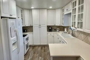 cocina blanca con electrodomésticos blancos y suelo de madera en Deer Suite HOT TUB GAME ROOM SLEEPS 2, en Ahwahnee