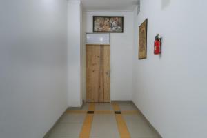 a hallway with a wooden door in a room at OYO Flagship Mg Mehak Garden in Darbi