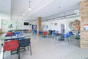 a restaurant with tables and chairs in a room at OYO Flagship Mg Mehak Garden in Darbi