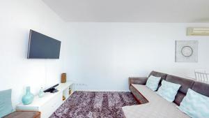uma sala de estar com um sofá e uma televisão de ecrã plano em Happy Building By GW Holidays em Lisboa