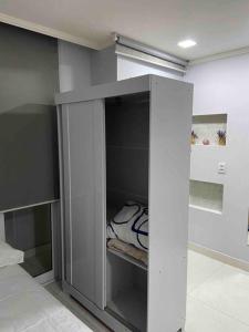 a white cabinet in a room with a bed at Flat Completo in Vila Velha