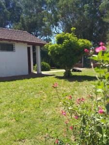 un patio con flores rosas y una casa en Chalet Mitaluya en Miramar