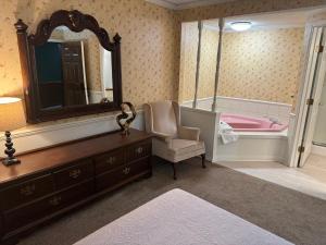 La salle de bains est pourvue d'un miroir, d'une chaise et d'une commode. dans l'établissement Fenway House Hotel, à Fennimore