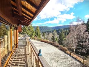 un balcón de una casa con vistas a las montañas en Chalet Pura Vida - En pleine nature, tout confort, en Le Valtin