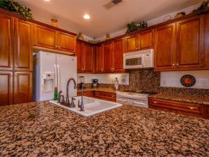 a kitchen with wooden cabinets and a white refrigerator at POOL SIDE, with free WiFi and GOLF PASS in La Ponderosa