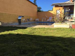 a backyard with a swimming pool and a house at Casa de Campo Atibaia c/ Piscina Aquecida in Atibaia