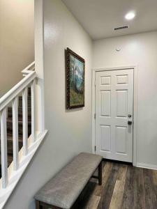 a hallway with a bench next to a white door at Vacation or Business trip in Downey