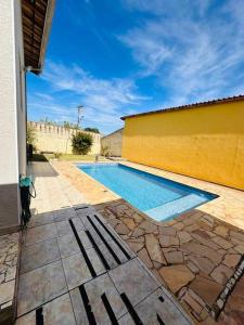 a swimming pool sitting next to a yellow building at Casa de Campo Atibaia c/ Piscina Aquecida in Atibaia
