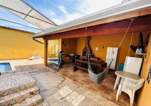 a house with a patio with a hammock on it at Casa de Campo Atibaia c/ Piscina Aquecida in Atibaia