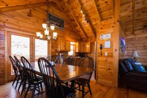 a dining room with a wooden table and chairs at Dancing Bears Cabin Breathtaking Sunrise Mountain Views! in Old Fort