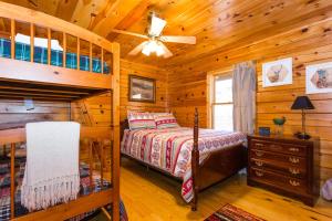 a bedroom with a bunk bed in a wooden cabin at Dancing Bears Cabin Breathtaking Sunrise Mountain Views! in Old Fort