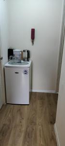eine kleine Küche mit einem Kühlschrank und einer Mikrowelle in der Unterkunft Wembley house in London