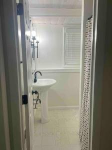 a white bathroom with a sink and a shower at 2023 Remodeled 4bed/2bath Home! in Gansevoort