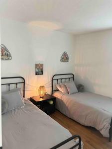 a bedroom with two beds and a table with a lamp at 2023 Remodeled 4bed/2bath Home! in Gansevoort