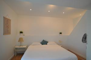 ein Schlafzimmer mit einem weißen Bett in einem Zimmer in der Unterkunft L'Hirondelle - Charming flat - in Blotzheim