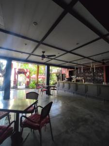 un restaurante con mesas y sillas y un bar en Hotel Laguna del Cocodrilo, en Tamarindo