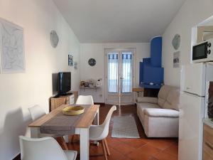 una cucina e un soggiorno con tavolo e divano di Appartamento Sole a Cala Gonone