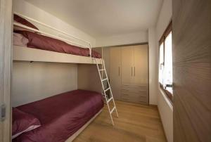 a bedroom with two bunk beds and a ladder at Da Elda in Belluno