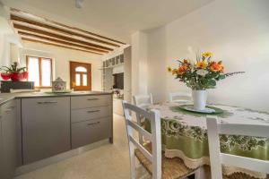 a kitchen with a table with a vase of flowers on it at Da Elda in Belluno